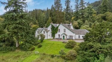 Ormidale House & Estate, Argyll – White-rendered country house with slate roof surrounded by mature woodland and manicured lawn.
