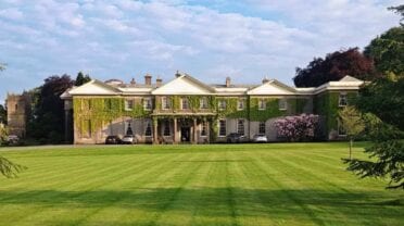 Buckland House, Devon – Georgian country house with ivy-covered façade and manicured lawn.