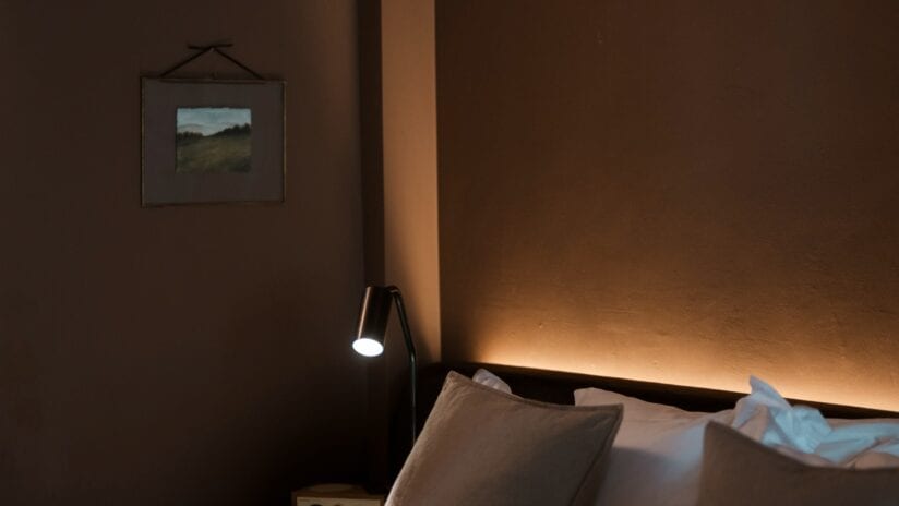 Hyll Hotel, Gloucestershire – Bedroom with framed landscape artwork, black reading lamp, and warm ambient lighting.
