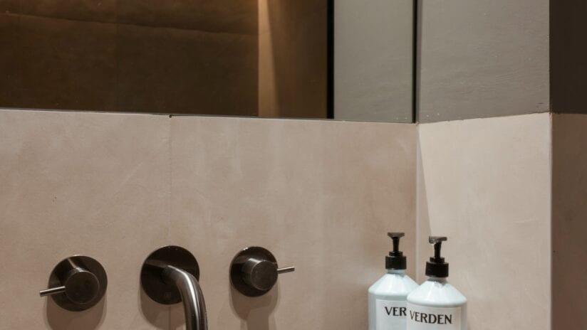 Hyll Hotel, Gloucestershire – Modern bathroom with cream tiled splashback, black wall-mounted taps and Verden toiletries.