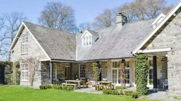 Crogen Estate, Denbighshire – Stone country house with slate roof, ivy-clad terrace and manicured lawn.