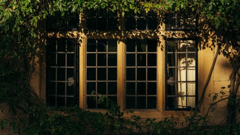 Hyll Hotel, Gloucestershire – Ivy-clad stone building with multi-pane windows and climbing vegetation.
