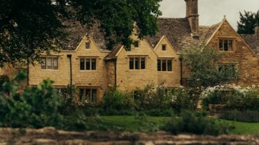 Hyll Hotel, Gloucestershire – Cotswold stone country house with gabled roofline, ivy-covered walls and manicured gardens.