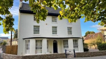 Brookside, Herefordshire – White-rendered Georgian house with slate roof and sash windows, stone boundary wall.