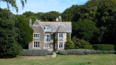 Lorton House, Dorset – Stone country house with slate roof and ivy, surrounded by mature woodland and hedged grounds.