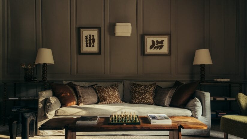 Hyll Hotel, Gloucestershire – Elegant sitting room with panelled walls, upholstered sofa and side tables with table lamps.