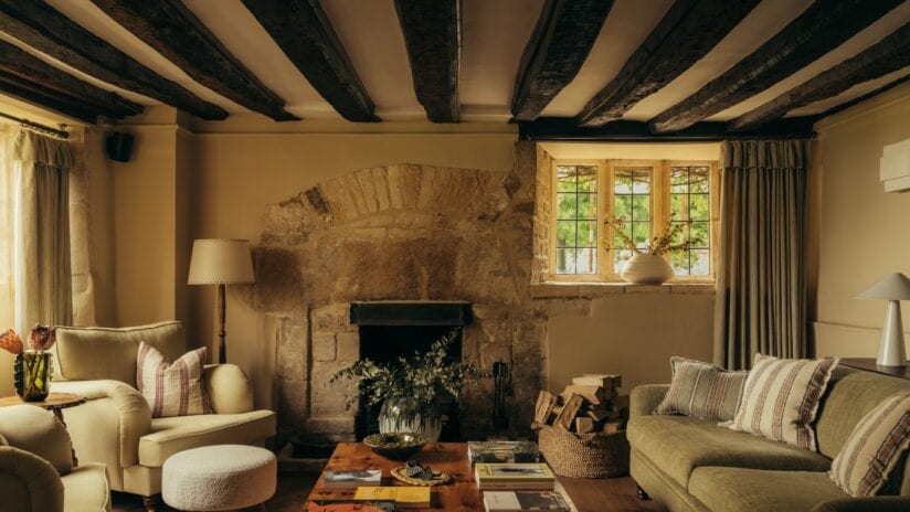 Hyll Hotel, Gloucestershire – Beamed sitting room with stone fireplace and sash windows overlooking grounds.