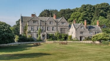 Northcourt House, Hampshire – Stone country house with ivy-covered facade, manicured lawns and wooden farm gates.