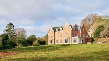 Cheltenham House, Gloucestershire – Red-brick Victorian country house with distinctive peaked gables set in manicured parkland.