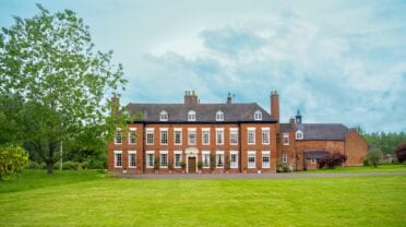 Blyth Hall, Warwickshire – Georgian red-brick country house with manicured lawns and mature trees.