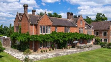Northfields House, West Sussex – Victorian brick country house with ivy-covered ground floor and manicured lawn.