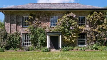 Old Rectory and Coach House – Stone country house with ivy-covered façade, sash windows and wisteria flowering climbers.