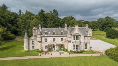 Wardhill Castle, Aberdeenshire – Stone castle with crenellated towers and turrets, surrounded by manicured lawns and mature woodland.